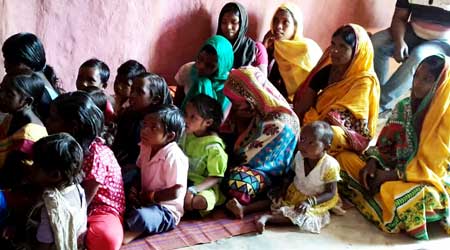 Children sitting on the floor listening to the VBS
